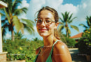 Smiling Woman with Sunglasses in Sunny Tropical Setting