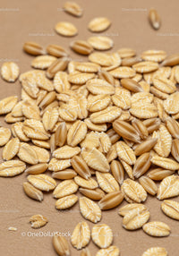 Close up of oat and wheat grains on brown surface