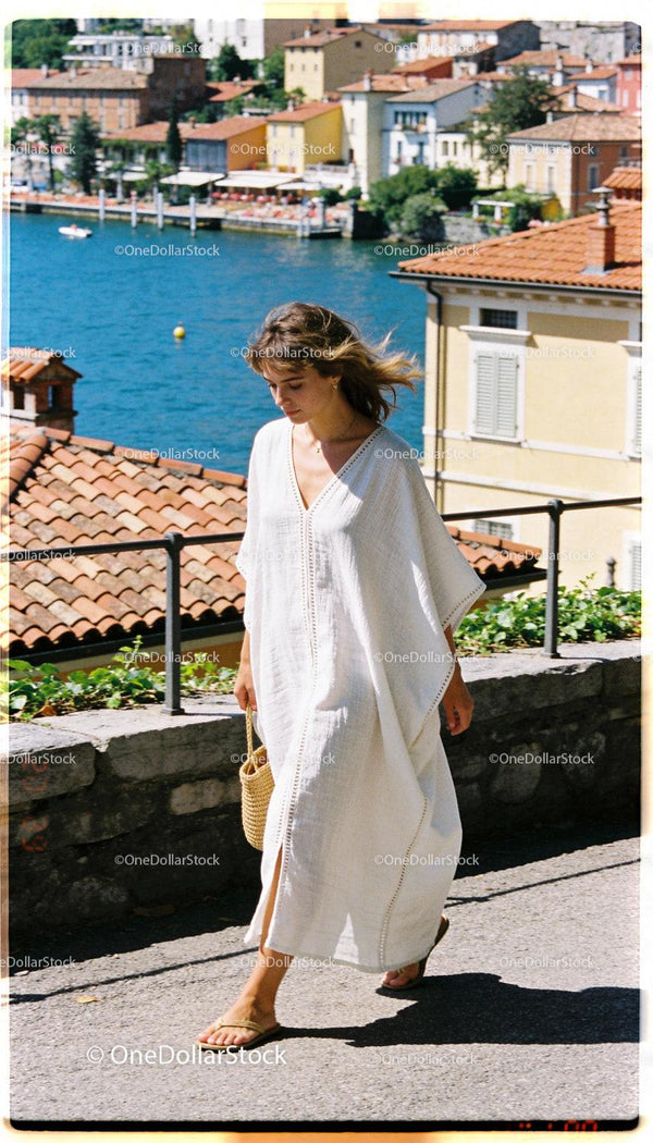 Woman in White Dress Walking Along Lake Promenade