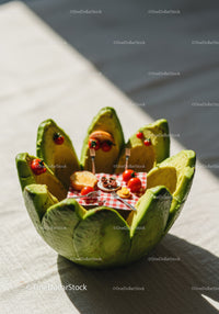 Miniature picnic set inside sliced avocado bowl