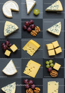 Assorted cheeses with grapes and walnuts on slate board