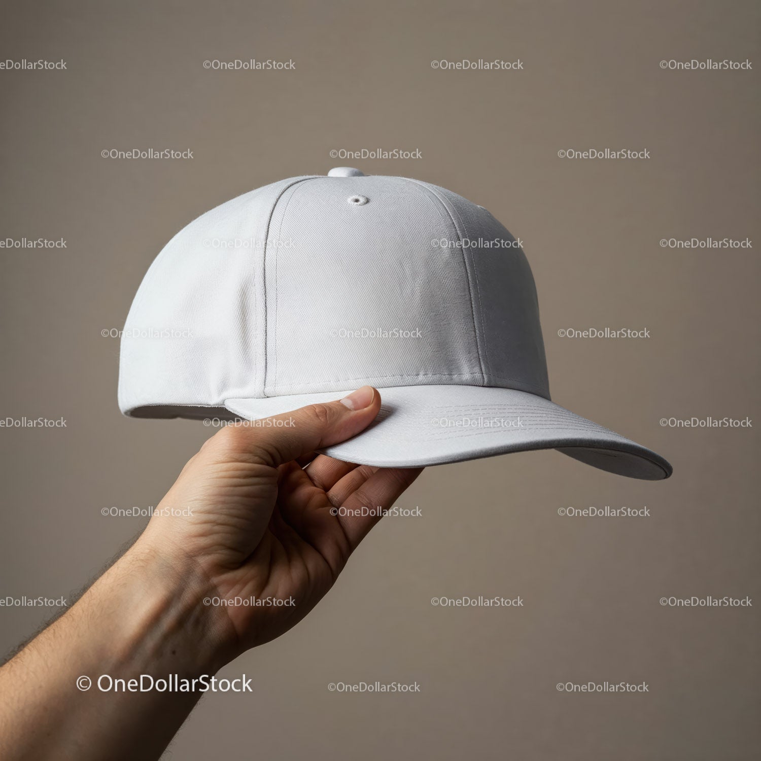 Ręka trzymająca prostą białą czapkę baseballową na neutralnym tle