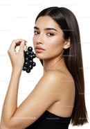 Elegant Woman with Black Grapes for Health and Beauty Concept