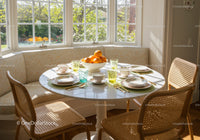 Sunlit breakfast nook with cozy seating and fresh oranges