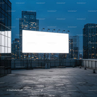 Empty illuminated billboard on rooftop at dusk