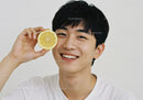 Joyful Young Man Holding Fresh Lemon Slice
