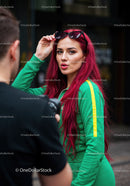 Vibrant Red Hair Woman in Green Tracksuit with Sunglasses in City
