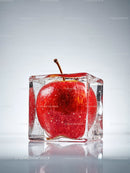 Fresh red apple frozen inside a clear ice cube