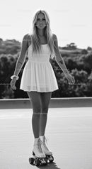 Young Woman Skating Outdoors in Vintage Style Dress