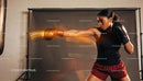 Focused woman training boxing punch in studio