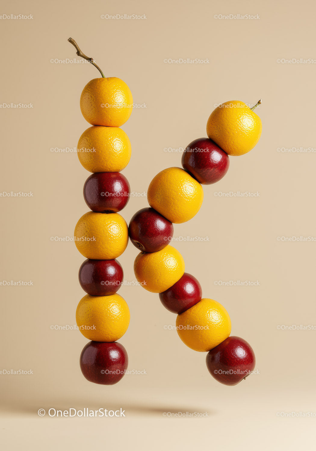 Letter K formed with stacked yellow and red fruits