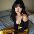 Stylish Young Woman Sitting on Bed in Modern Bedroom