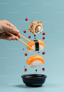 Hand Holding Chopsticks with Sushi over Soy Sauce Bowl