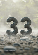 Twin Black Marble Number 33 Standing on Pebbly Ground