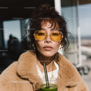 Stylish Woman With Yellow Sunglasses Sitting Outdoors in City