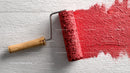 Red Paint Application with Roller on White Wooden Surface