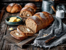 Fresh Rustic Loaf of Bread with Butter on Wooden Table