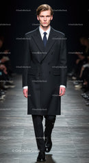 Male model walking runway in tailored black coat suit