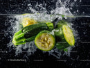 Fresh Green Zucchini Slices with Water Splash in Dark Background