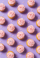 Pink Frosted Cupcakes with Sprinkles on Purple Background