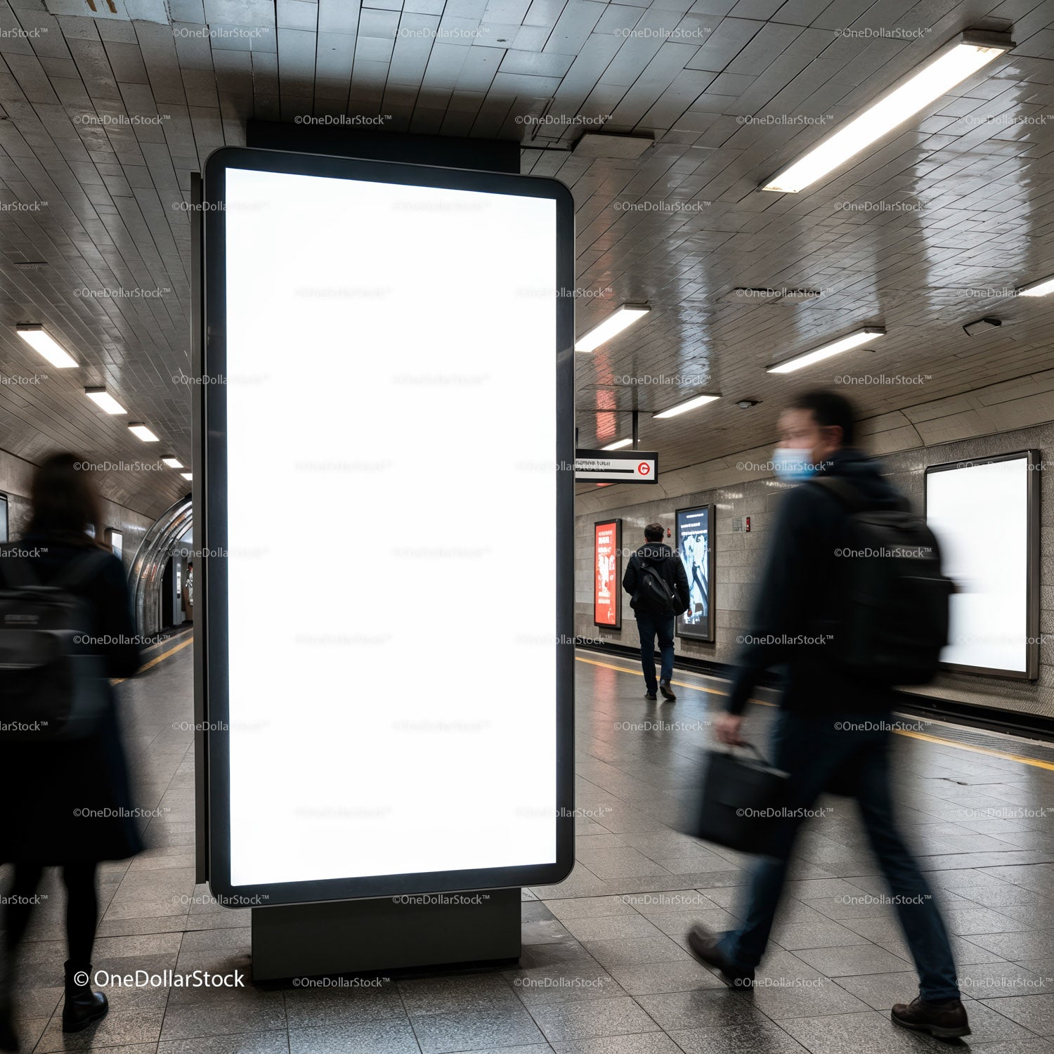 Pasażerowie mijając pustą reklamę na stacji metra