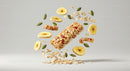 Granola Bar with Banana Chips and Seeds Floating on Gray