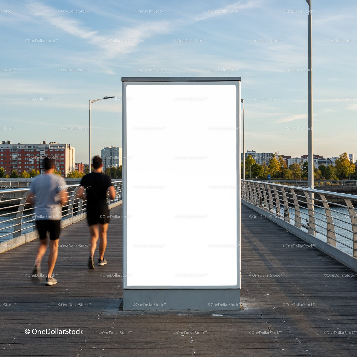 Biegacze mijają pusty billboard na moście nad rzeką