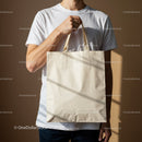 Man holding blank beige reusable canvas tote bag
