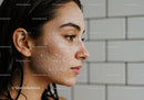 Side portrait of young woman with facial exfoliating scrub