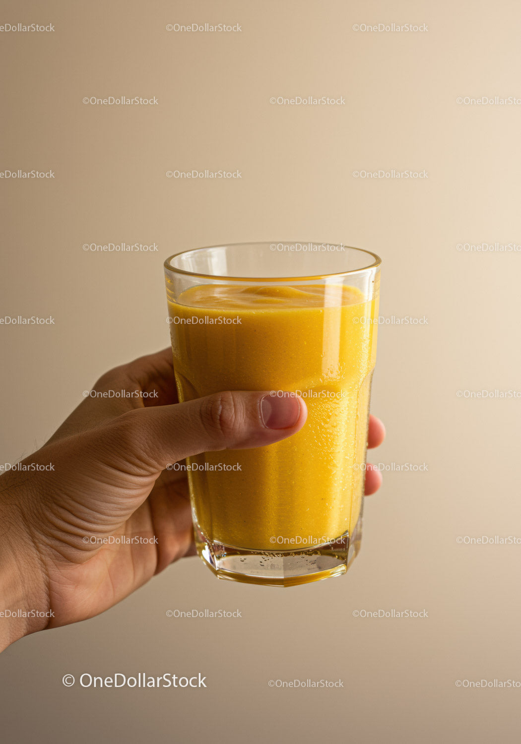 Hand Holding Glass of Fresh Mango Smoothie