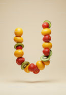 Fresh fruits forming letter U on beige background
