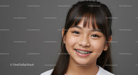 Young Girl With Bright Smile Wearing Braces on Gray Background