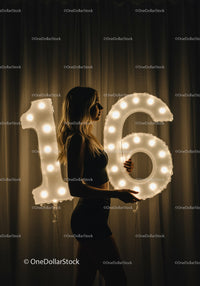 Young woman celebrating sweet sixteen with illuminated balloons