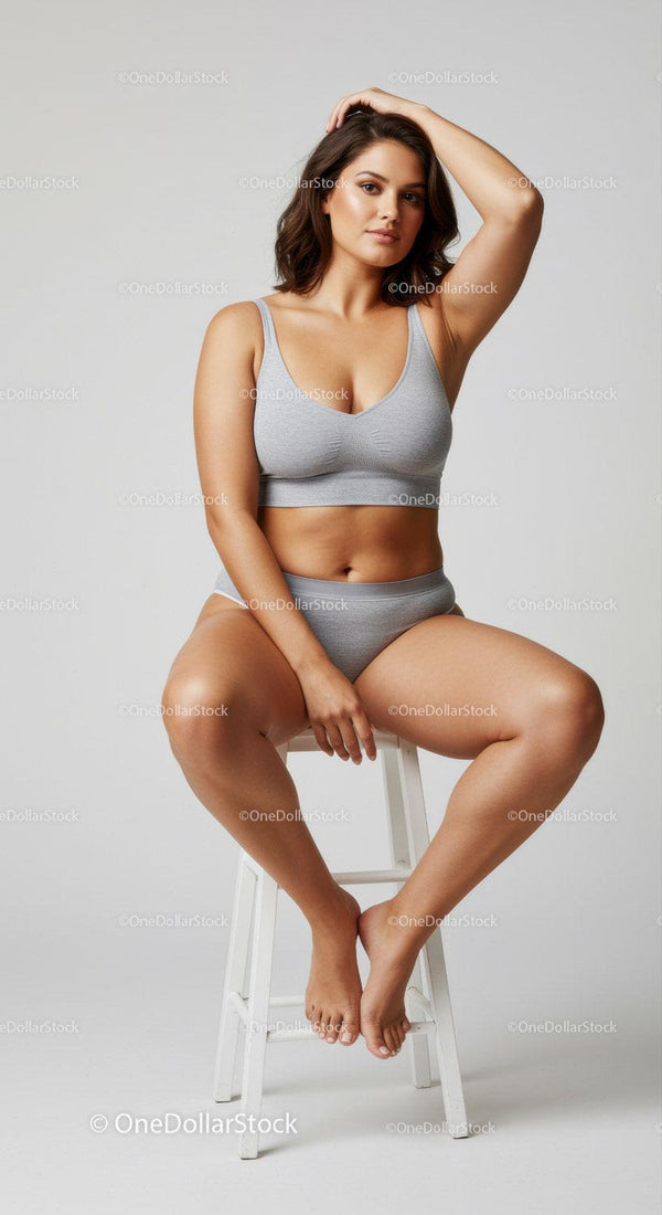 Confident Woman in Grey Lingerie Sitting on a White Stool Studio Portrait