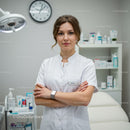 Woman doctor in white coat standing in modern medical clinic
