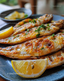 Grilled Fish with Lemon Wedges and Fresh Herbs