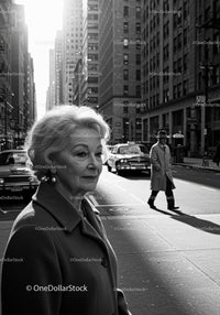 Elderly Woman in Busy City Street Surrounded by Vintage Cars