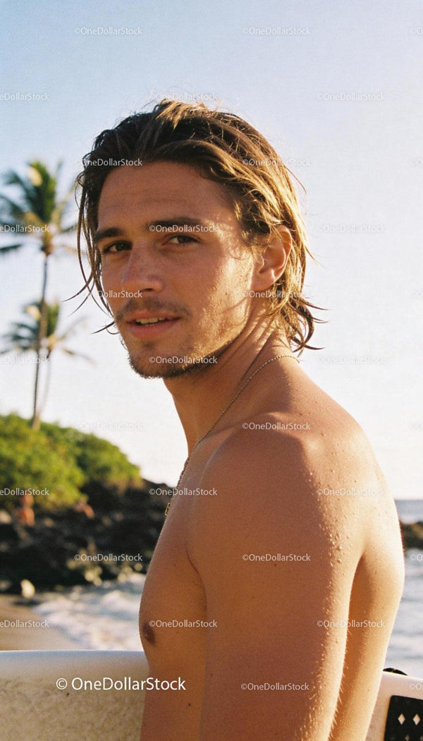 Young surfer with wet skin enjoying tropical beach sunset