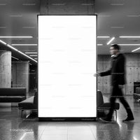 Blurred man walking past illuminated blank billboard indoors