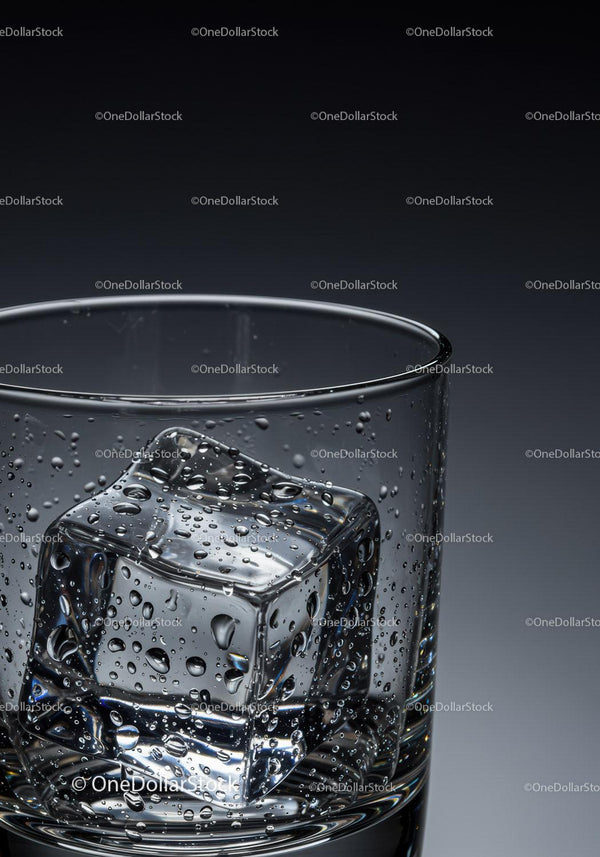 Close-up of wet ice cube inside clear drinking glass