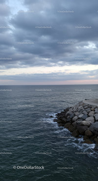 Stormy Sky Over Calm Ocean with Rocky Shore