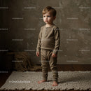Thoughtful toddler standing barefoot on soft rug indoors