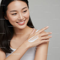 Smiling Young Woman Applying Moisturizer with Healthy Skin