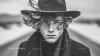Monochrome Portrait of Young Man with Wide-Brimmed Hat and Intense Gaze