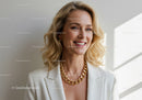 Professional Woman with Bright Smile Wearing White Blazer and Gold Jewelry