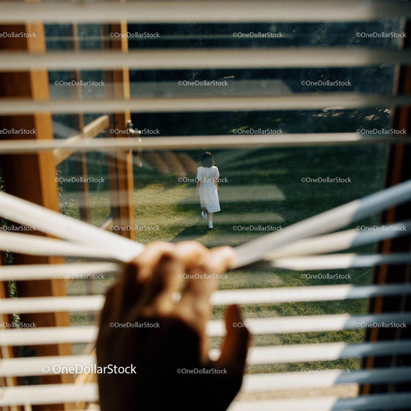 Person Watching Alone from Window Blinds Outdoors