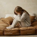 Young girl in cozy knitwear sitting on brown sofa