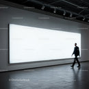 Man walking past large illuminated display in modern gallery