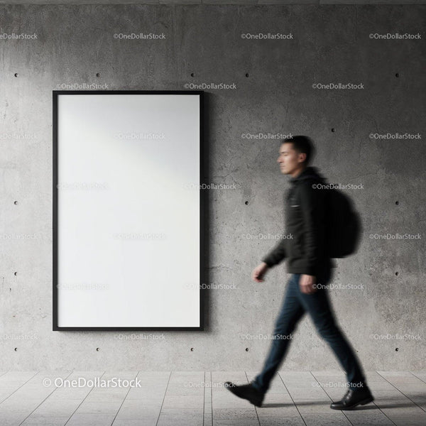 Man walking past blank poster on concrete wall JPG Mockup Image