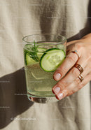 Refreshing cucumber water with rosemary in hand